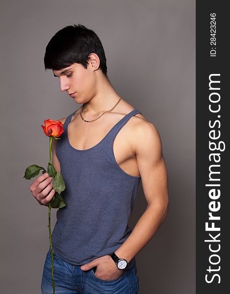 Muscular man with a rose in hands