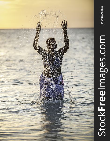 A Young Girl Splashing Water In The Ocean