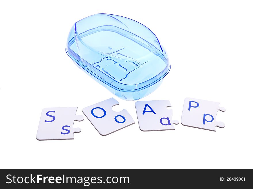 Blue soap-dish and puzzle pieces with letters isolated on white.