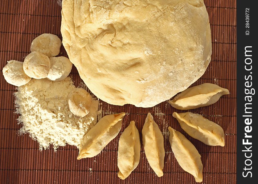 Tasty dumplings with wheat pastry on the brown background. Tasty dumplings with wheat pastry on the brown background