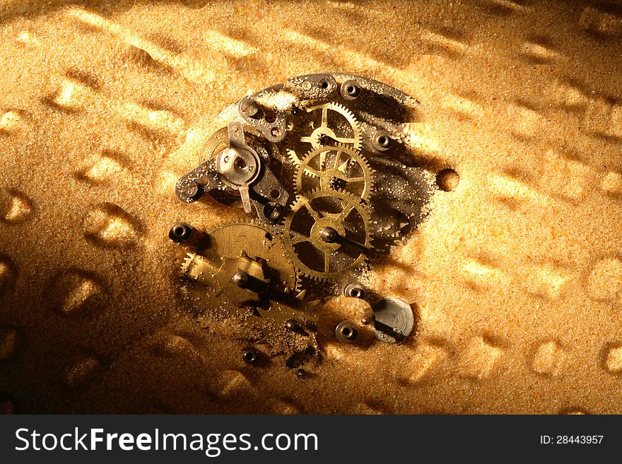 Business concept. Old clock mechanism on sand surface. Nice background. Business concept. Old clock mechanism on sand surface. Nice background