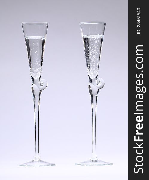 Two drinnking glasses with outline of a flute used for drinking sparkling wine in front of neutral light grey background. Two drinnking glasses with outline of a flute used for drinking sparkling wine in front of neutral light grey background