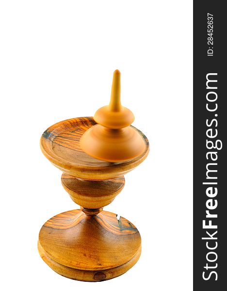 Spinning top made ​​of wood spinning on a special stand carved out of wood. Spinning top made ​​of wood spinning on a special stand carved out of wood