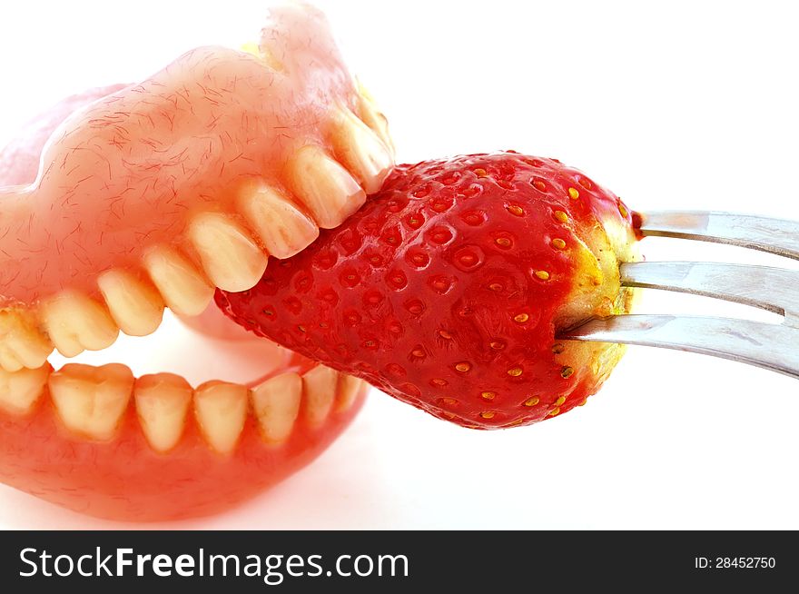 Strawberries sandwiched artificial teeth, photographed against a white background. Strawberries sandwiched artificial teeth, photographed against a white background