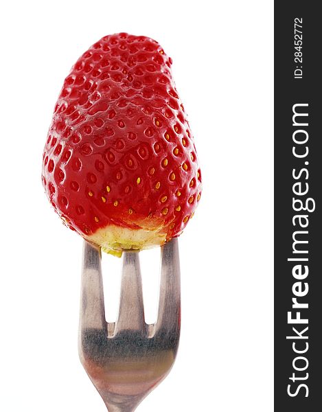 Strawberry worn on threetheethed fork photographed against a white background. Strawberry worn on threetheethed fork photographed against a white background