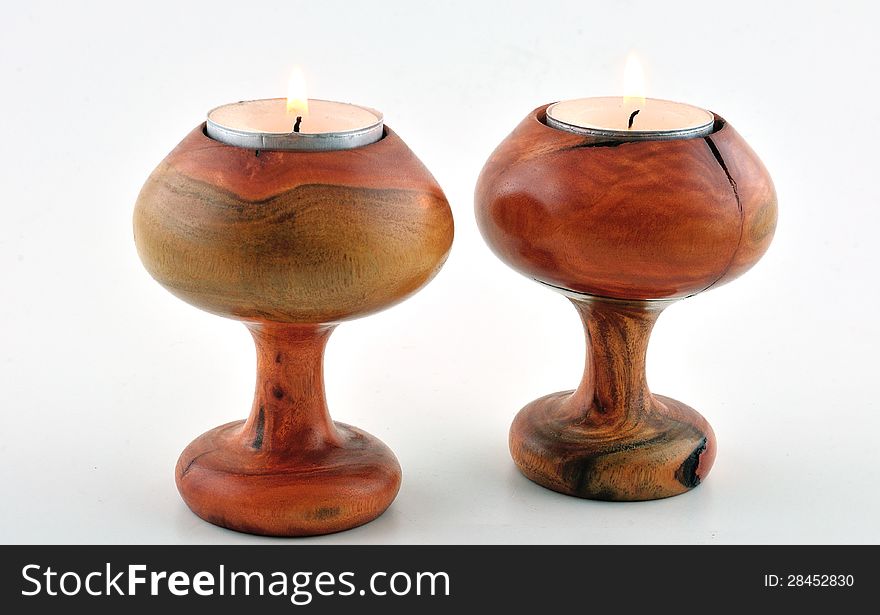 Two wooden candlesticks carved mahogany and photographed against a white background