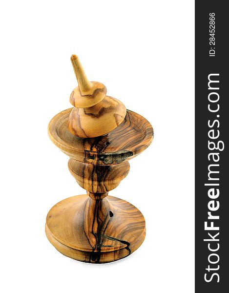 Spinning top made ​​of wood is on a special stand carved out of wood. Spinning top made ​​of wood is on a special stand carved out of wood