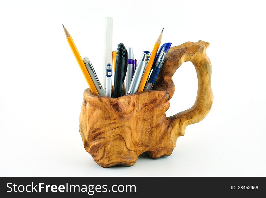 Wooden carved mug with pencils carved from wood and photographed against a white background