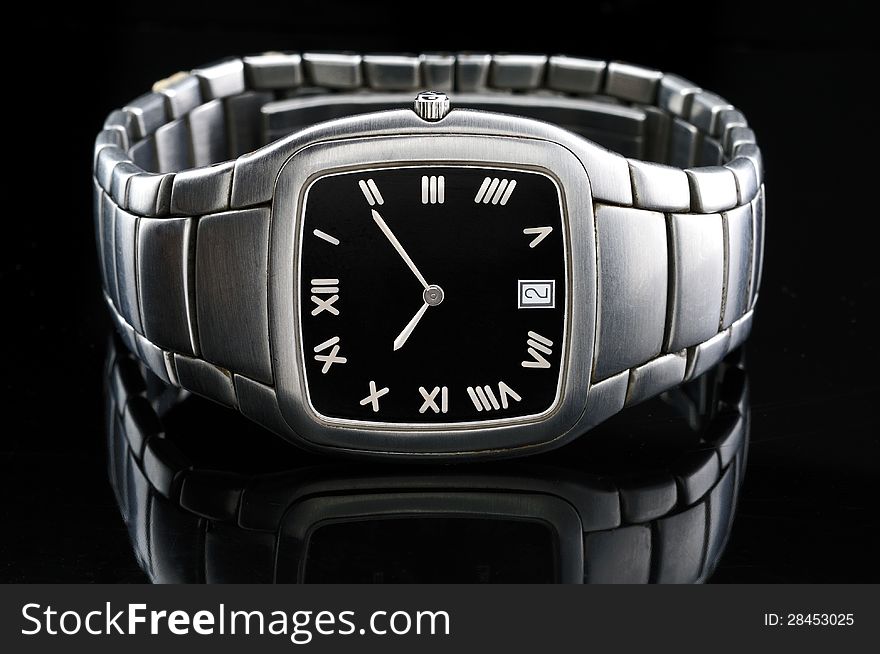 Wristwatch elegant in steel with bracelet photographed against a black background