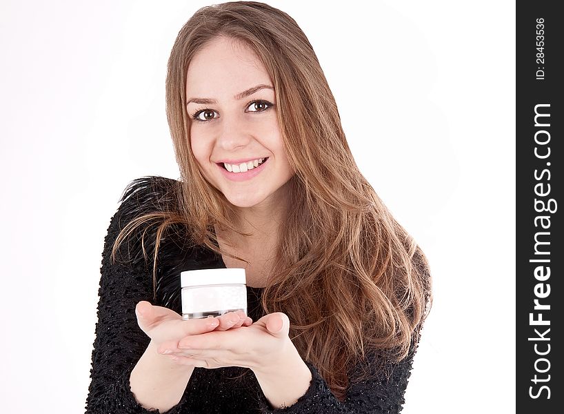 Beautiful woman shows her face cream isolated on white background