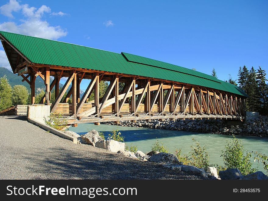 A wooden pedestrian bridge spanning the river to allow people to cross into town.