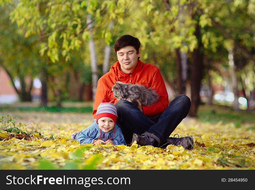 Family with grey persian cat in the autumn park. Family with grey persian cat in the autumn park