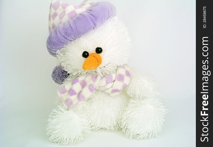 Stuffed snowman plush toy wearing a hat and scarg on a pale gray background