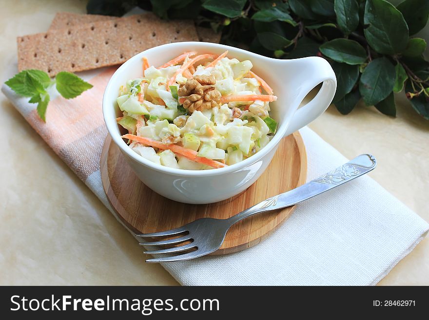 Salad with cabbage, carrot, apples and pears with walnuts