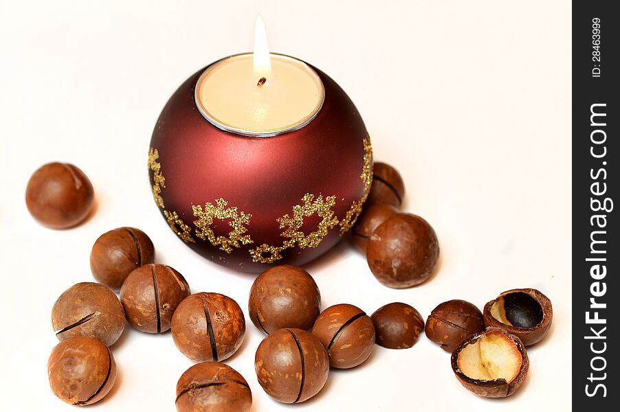 Christmas candle, macadamia nuts on white background. Christmas candle, macadamia nuts on white background.