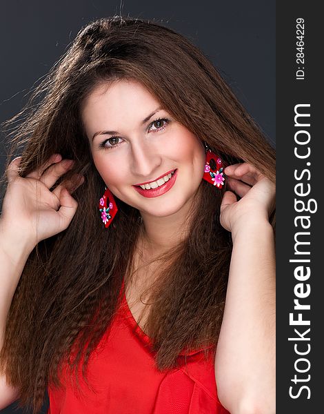 Portrait of a beautiful woman in a red dress and a snow-white smile