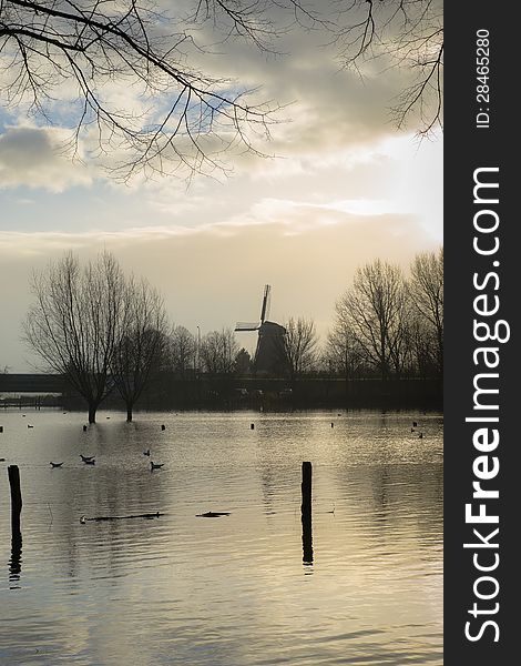 Windmill in river flood with backlight. Windmill in river flood with backlight