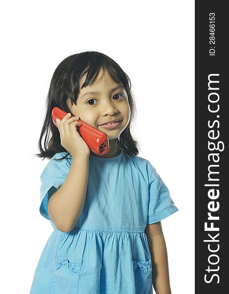 Little girl holding red wireless telephone. Isolated over white background