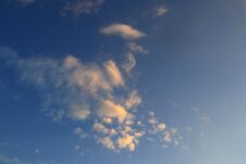 Light Cirrus Small Orange Clouds In The Blue Sky Are Illuminated By The Morning Sunlight. Royalty Free Stock Image