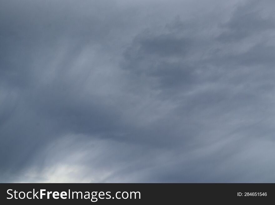 Large gray storm clouds of smooth and unusual shapes during a thunderstorm and a rainy day