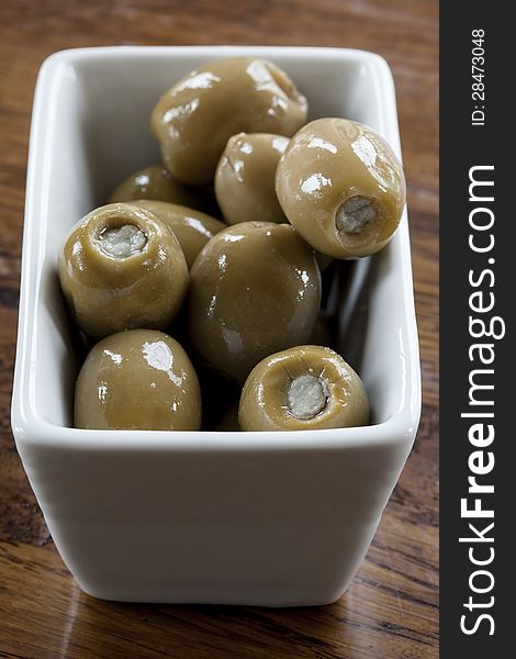 Green olives stuffed with blue cheese in a white bowl. Green olives stuffed with blue cheese in a white bowl.