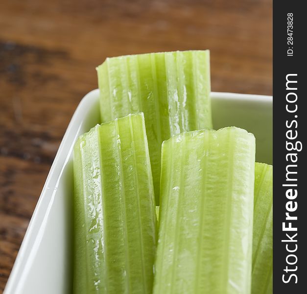 Delicious celery stalks in a white bowl.