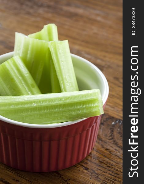 Delicious celery stalks in a red and white bowl.