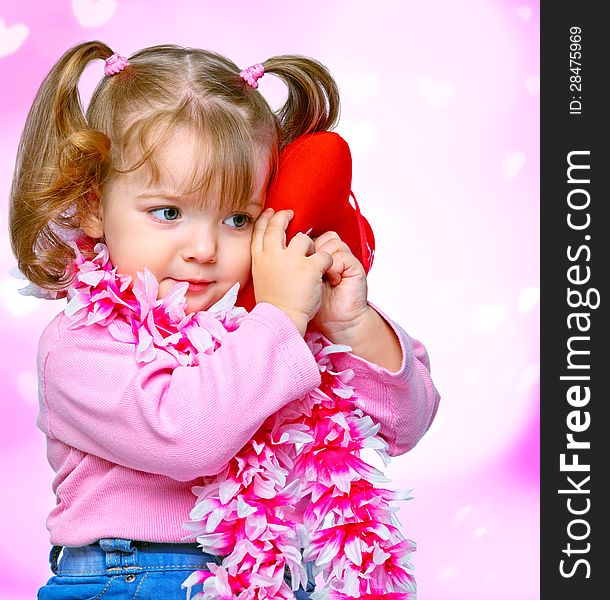 Portrait of a beautiful little girl holding a heart