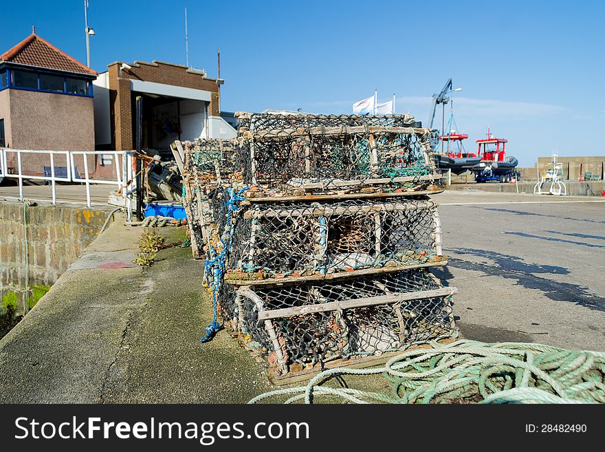 Lobster pots stacked on pier in Scotland