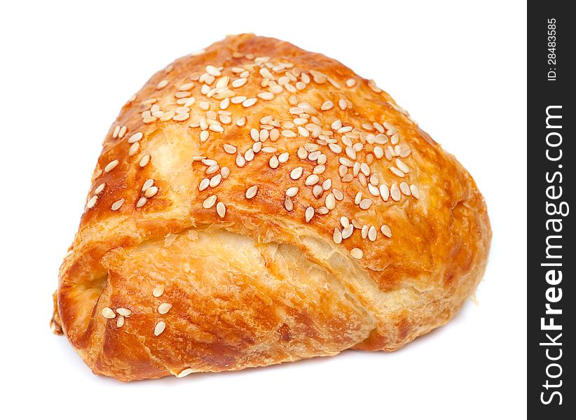 Pie from flaky pastry strewed with sesame seeds on a white background