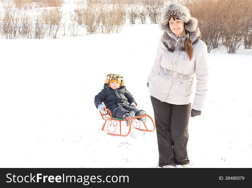 Mother towing her son in the snow