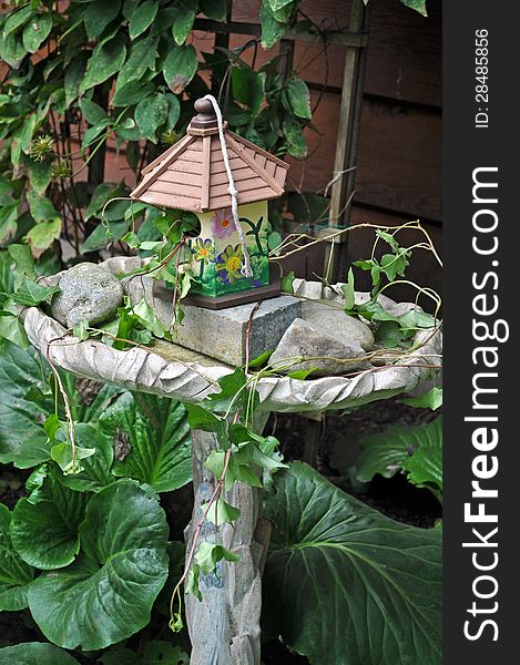 Decorative birdhouse and birdbath in the garden
