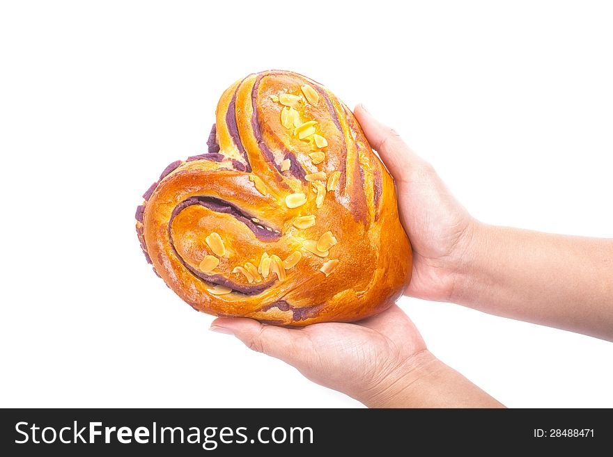 Heart shaped bread with love in hands on white background