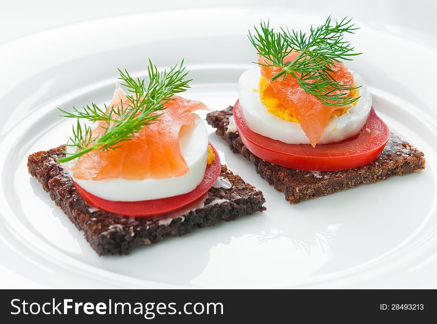 Sandwich with smoked salmon, tomato and egg topped with fresh dill. Sandwich with smoked salmon, tomato and egg topped with fresh dill