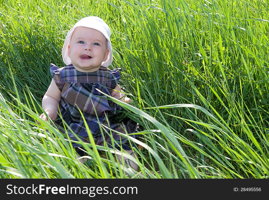 Small child sitting on the green grass. Small child sitting on the green grass