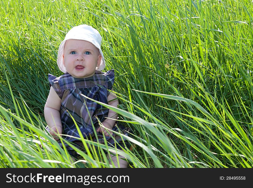 Small child sitting on the green grass. Small child sitting on the green grass