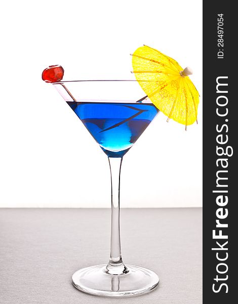 Cocktail drink in cocktail glass with cherry and umbrella