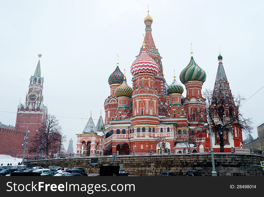 St Basil Temple and Spasskaya Tower of Kremlin at wintertime during snowfall. The Red Square, Moscow, Russia. St Basil Temple and Spasskaya Tower of Kremlin at wintertime during snowfall. The Red Square, Moscow, Russia