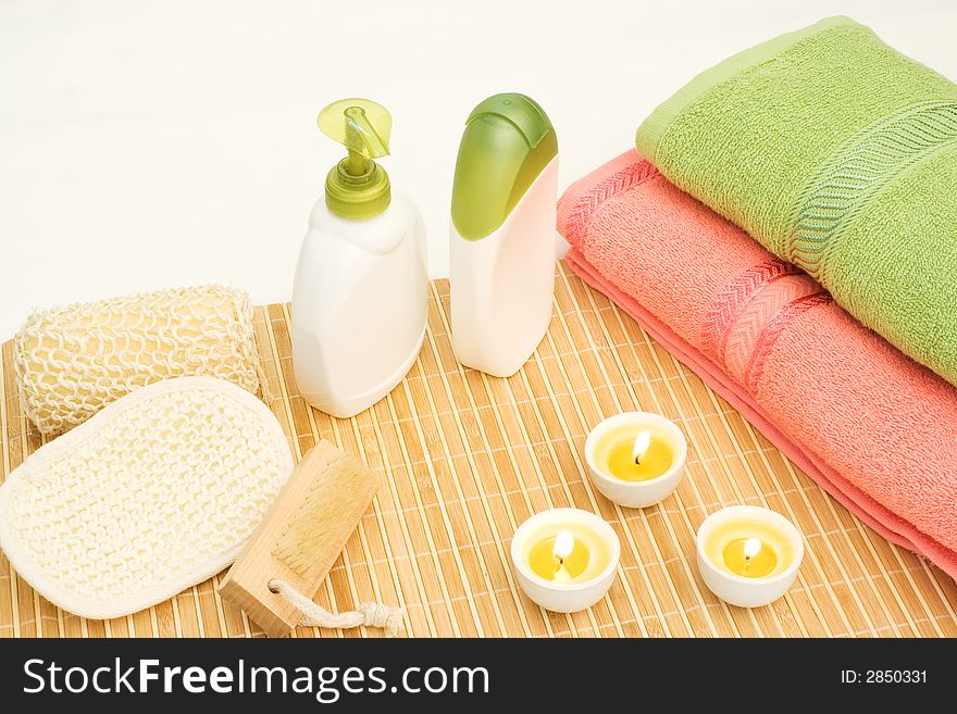 Pink and green towel with soap bottles on bamboo. Pink and green towel with soap bottles on bamboo