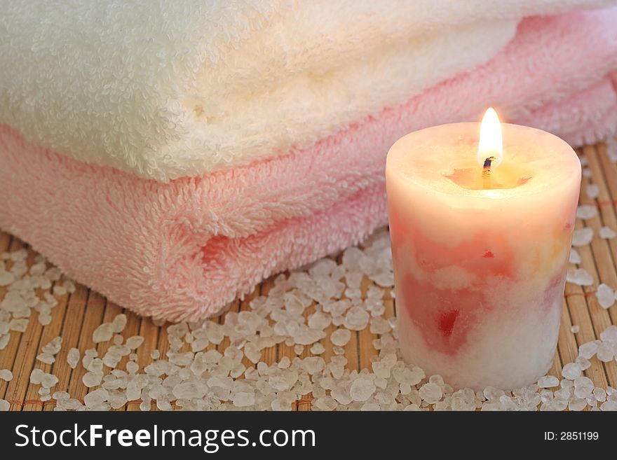 Rosa candle,towels and sea salt on a bamboo mat