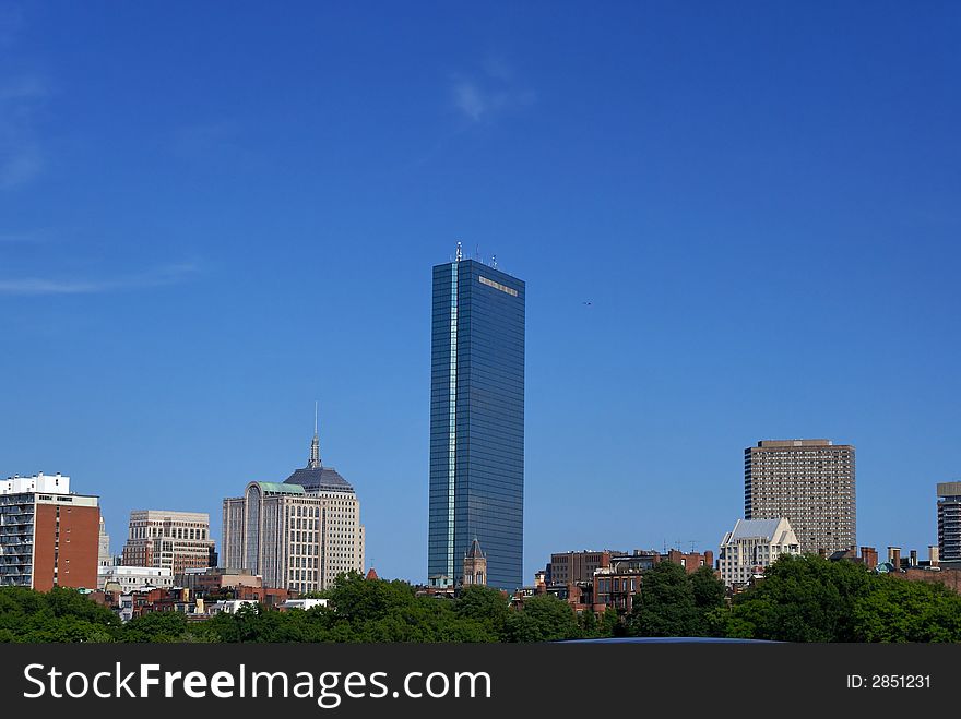 View of the boston skyline above the trees along the coast of the charles river. View of the boston skyline above the trees along the coast of the charles river