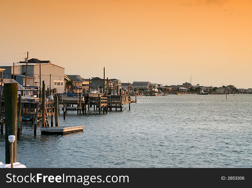 Buildings and boat docks on the sound side of an island gleaming in the glow of the evening sun. Buildings and boat docks on the sound side of an island gleaming in the glow of the evening sun