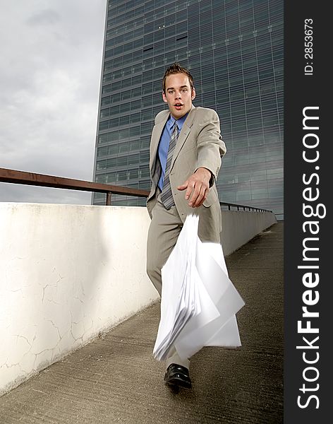 Bad day - fumbler businessman with mobile phone in front of modern business building. Bad day - fumbler businessman with mobile phone in front of modern business building.