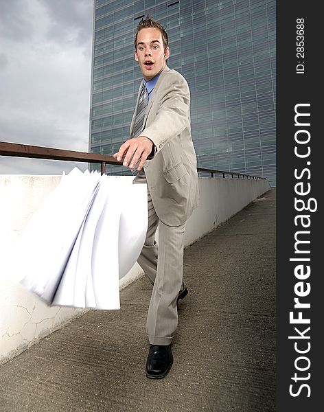 Bad day - fumbler businessman with mobile phone in front of modern business building. Bad day - fumbler businessman with mobile phone in front of modern business building.