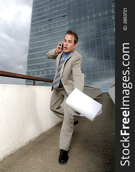 Bad day - fumbler businessman with mobile phone in front of modern business building. Bad day - fumbler businessman with mobile phone in front of modern business building.