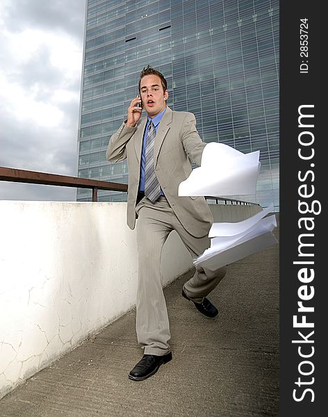 Bad day - fumbler businessman with mobile phone in front of modern business building. Bad day - fumbler businessman with mobile phone in front of modern business building.