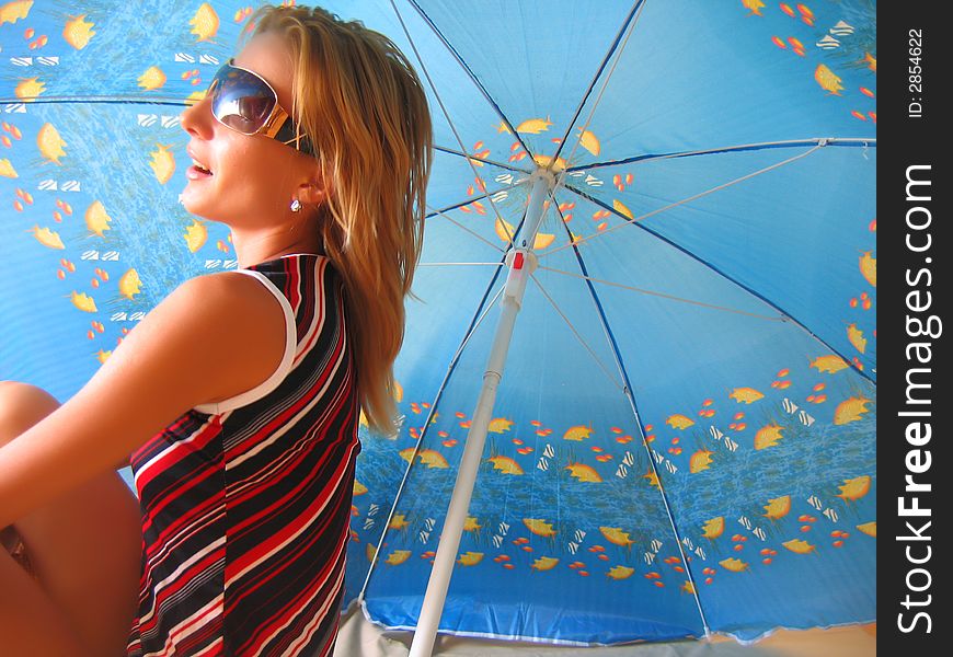 Girl sitting under an umbrella