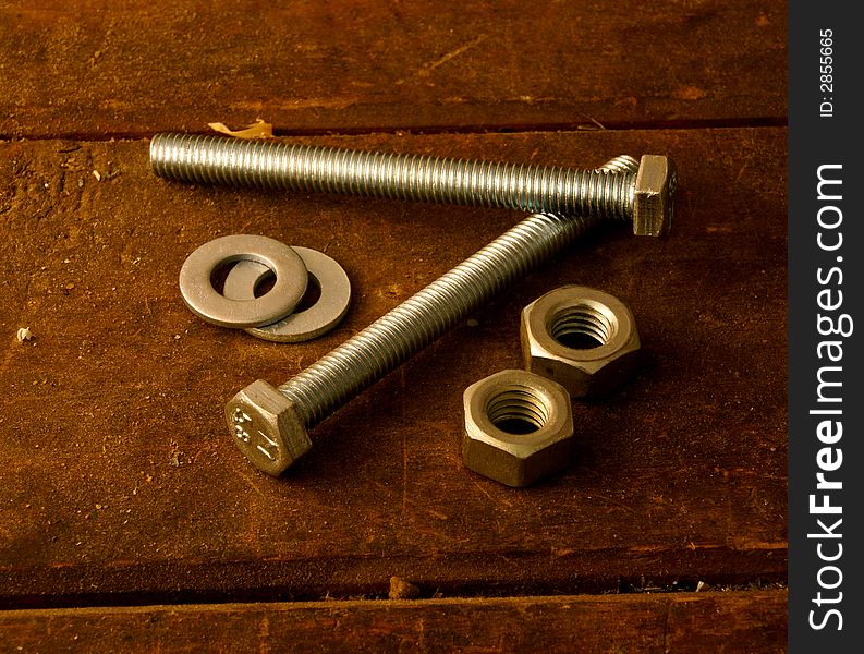 Screws, female screws and washers on work table. Screws, female screws and washers on work table.