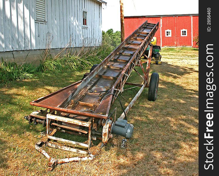 An old, rusty farm loader for hay