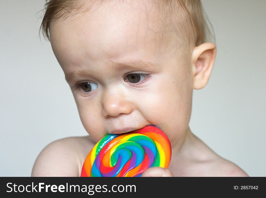 Image of cute toddler licking a colorful lollipop. Image of cute toddler licking a colorful lollipop